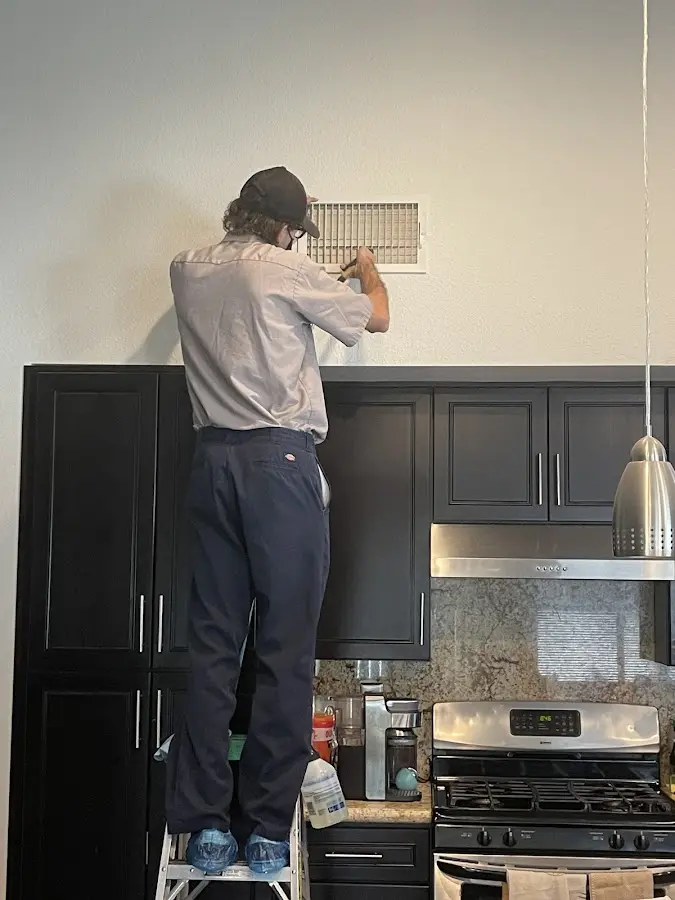 Technician inspecting an air vent during HVAC service in Aberdeen